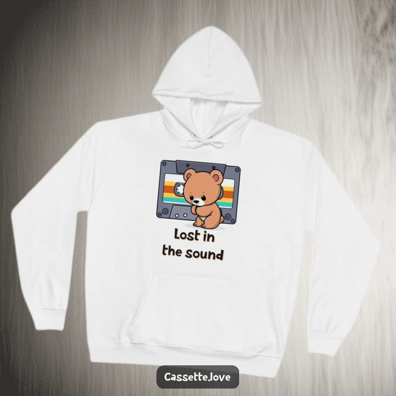 Funny Hoodie showcasing a curious bear cub sniffing the tape ribbon of a giant cassette, perfect for retro music explorations.